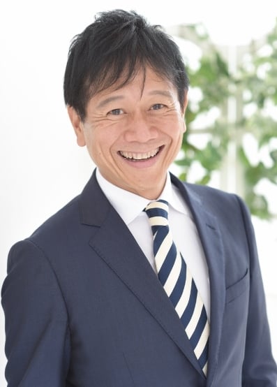 笑顔でスーツ姿の中川コーイチ氏